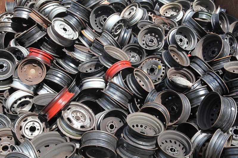 A stack of used steel and alloy wheel rims