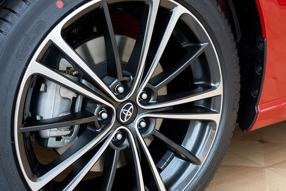 A factory alloy wheel with the brake disc and caliper visible behind the spokes